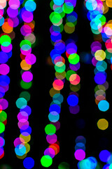 Colored blurred lights, defocused background. New Year Christmas background with multicolored blurred lights.