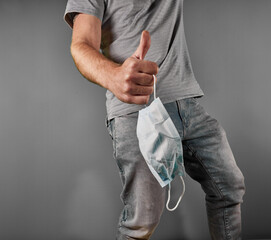 Man with thumb up holding medical mask