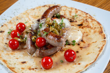 Grilled sausage in a tortilla with tomato and spices
