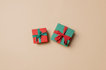 red gift box with green ribbon and green with red on stark white background