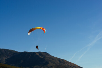 Paragliding Pilot Flying a Paraglider - 468448173