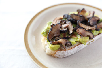 Toast with avocado and grilled mushroom in white background