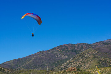 Paragliding Pilot Flying a Paraglider - 468448308