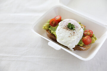 Poached eggs with avocado on toast in white background