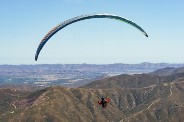 Paragliding Pilot Flying a Paraglider - 468448337