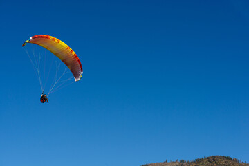 Paragliding Pilot Flying a Paraglider - 468448345