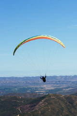 Paragliding Pilot Flying a Paraglider - 468448362