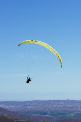 Paragliding Pilot Flying a Paraglider - 468448370