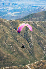 Paragliding Pilot Flying a Paraglider - 468452503