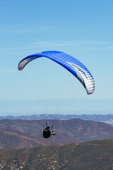 Paragliding Pilot Flying a Paraglider - 468452516