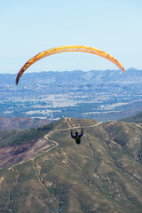 Paragliding Pilot Flying a Paraglider - 468452544