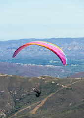 Paragliding Pilot Flying a Paraglider - 468452566
