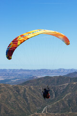 Paragliding Pilot Flying a Paraglider - 468452594
