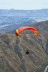 Paragliding Pilot Flying a Paraglider - 468452596