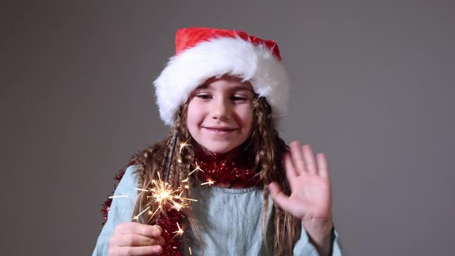 holidays, childhood and people concept - happy little girl with sparkler at home. Christmas. Slow Motion. Positive Emotions of People.
