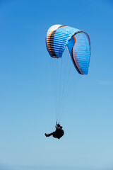 Paragliding Pilot Flying a Paraglider - 468452944