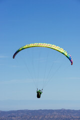 Paragliding Pilot Flying a Paraglider - 468452948