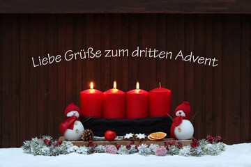 Adventsdekoration: Rote Adventskerzen mit Weihnachtsschmuck zum dritten Advent.