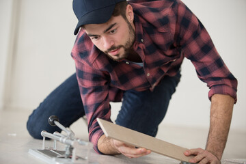 man cutting a ceramic floor tiles