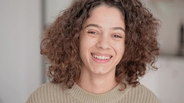 close up portrait young brunette with curly hair laughing looking camera joyful woman at home slow motion