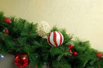 Christmas decoration in the form of a garland of spruce branches and red Christmas balls.