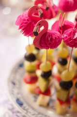 Canapé with cheese and fruit on a skewer with paper flamingo