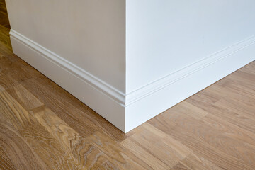 Detail of corner flooring with intricate crown molding and plinth.