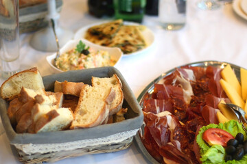 Spread of prosciutto, salami and cheese, served on a festive table. Selective focus.