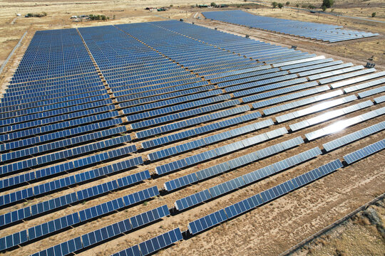 Aerial drone shot of a large solar array power plant in the desert generating clean electricity from the sun.