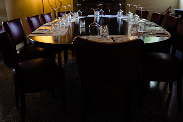 A large stately and elegant wooden table with cutlery served, ready for a business lunch.