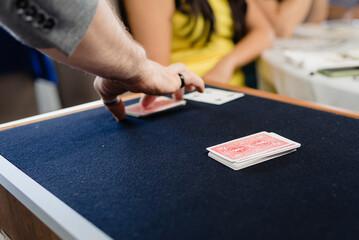 A magician performs a trick with cards face down on a mat.