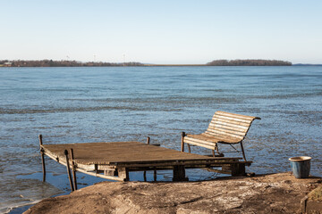 Fototapeta na wymiar wooden bench on an old pier on a frozen lake in Dalarna, Sweden