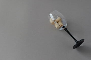 Top view of a wine glass goblet with wine corks on a gray background with place for text.
