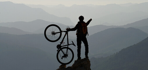 silhouette of a person on a mountain bike