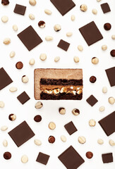 Top view of delicious chocolate mousse cake slice with the layers displayed and recipe ingredients arranged over white background. Restaurant menu and confectionery concept in flat lay style.