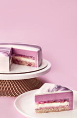 Delicious litchi and raspberry mousse cake on a stand and slice with the layers and texture...