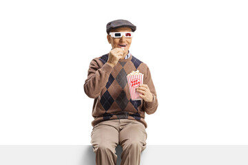 Elderly man sitting on a panel with popcorn and 3d movie glasses