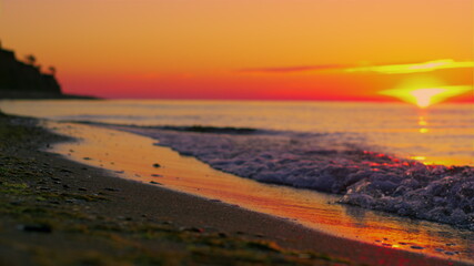 Sun rise over sea horizon reflecting at water surface at golden sunrise morning