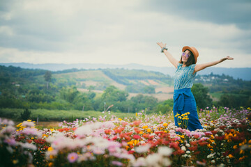 happy woman standing in beautiful blooming flower field
