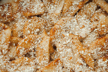 Close up of raw apple pie. Apple wedges sprinkled with nut crumbs