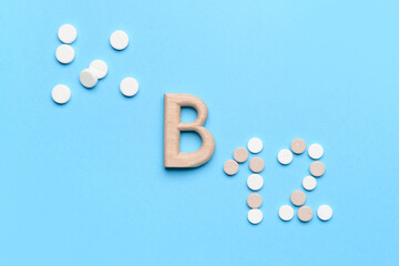 Vitamin B12 pills on color background