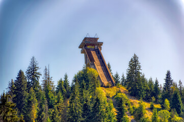 Abandoned ski  jumping hill surrounded by forest.