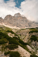 Dolomite mountains in Tre Cime, Italy, with green grass foreground during sunny summer day with blue sky