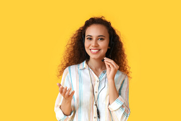 African-American consultant of call center in headset on yellow background