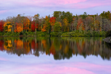 Price Lake in North Carolina at dawn with Fall color trees reflecting on the lake.