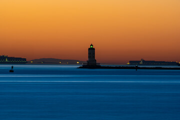 Long exposure at dawn of a lighthouse in Souther California with cargo vessels in background.