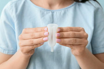 Female hands holding menstrual cup, closeup