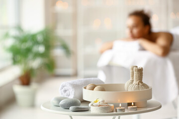 Beautiful spa composition with herbal bags on table in spa salon