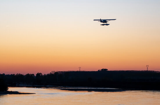 : Seaplane flies over the Po river at sunset., Cremona. Italy