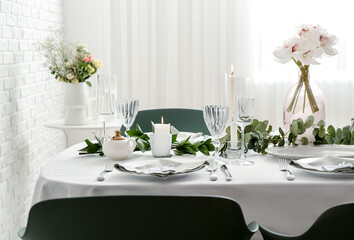 Beautiful table setting for wedding celebration with burning candles in restaurant